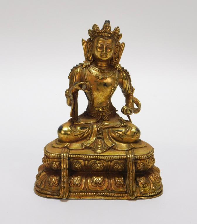 Tibetan Gilt Bronze Seated Buddha: Tibet,Early 20th Century Depicts a seated smiling Buddha wearing an elaborate crown upon a double lotus base. Bronze,7" t x 5 5/8" w x 4" d, From the collection of a Quincy, Massachusetts gentleman.