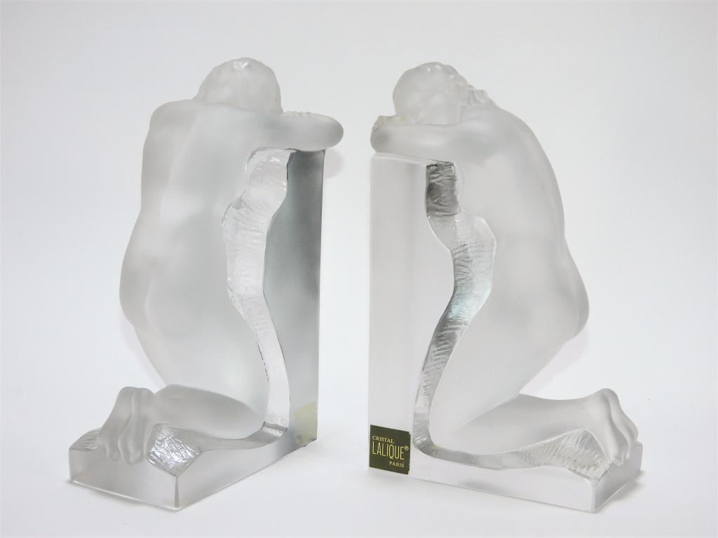 PR Lalique Nude Reverie Bookends: France,20th Century Pair of opposing bookends of frosted colorless glass nude women. Glass,Approx. 8 3/4" t x 5 1/4" w x 3 1/8" d. Marked "Lalique France" to outer end of bases. From the collection of
