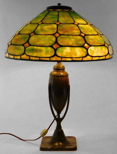 Tiffany Studios Leaded Green Glass Table Lamp: New York,Early 20th Century Geometric shaped green marbled glass panel lampshade over openwork bronze column supported by a square base. Overall 22" x 16 1/2" dia.Lampshade 7 1/4" x 16 1/2" dia.Bronze