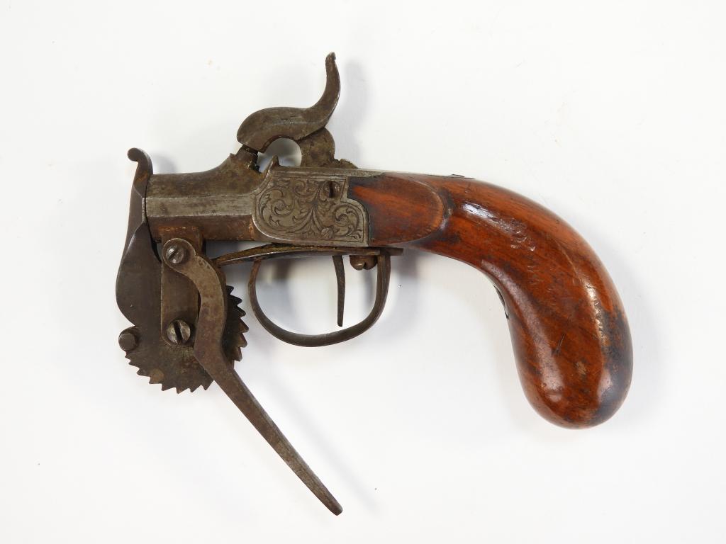 Percussion Powder Tester: England C. 1840s Walnut grip, steel frame engraved with foliate designs, and a steel measuring wheel with engraved lines on both sides. Overall lg. 5 1/2".