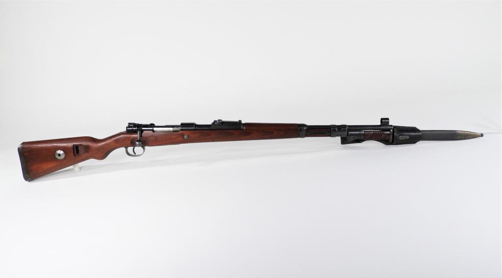 WWII German Model 98K Mauser Rifle and Bayonet: Germany C. 1942 .8mm, serial number 7877 all matching, walnut stock, steel fittings, marked on the receiver ring "bnz/42," and on the left of the receiver "Mod 98," sight hood, and a 44 dated bayonet,