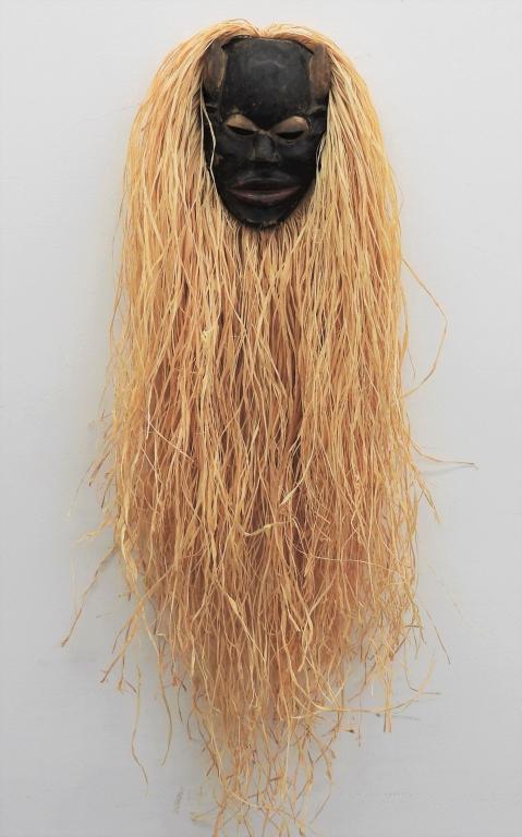 African Ibibio Tribe Ekpo Society Mask: Africa, Early 20th Century Depicts a horned face dyed black with down turned eyes, short nose, wide red mouth, and long dried grass mane. Mask 10" t x 7 3/8" w x 3 1/4" d.Overall length approx. 37 1/2
