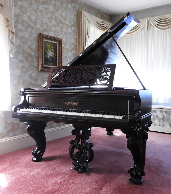 Chickering & Sons Concert Grand Piano: United States,Late 19th Century Ornate concert piano with acanthus leaf legs terminating in scroll feet with a finely carved lyre post. Widest portion of case 57" Smallest portion of case 32" Overall