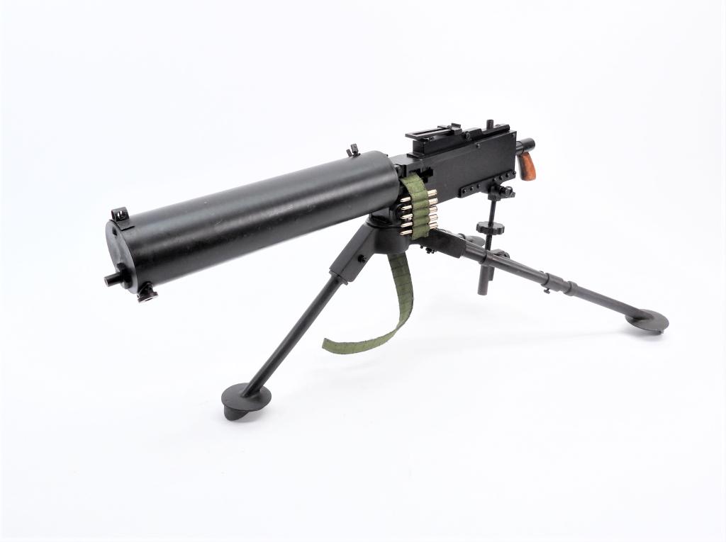 Inert Miniature Browning Model 1917 Machine Gun: , Miniature non-firing steel replica with blued finish, wooden grips, tripod with traverse and elevation, and a cloth belt with dummy rounds. Overall ht. 9".Overall lg. 22"