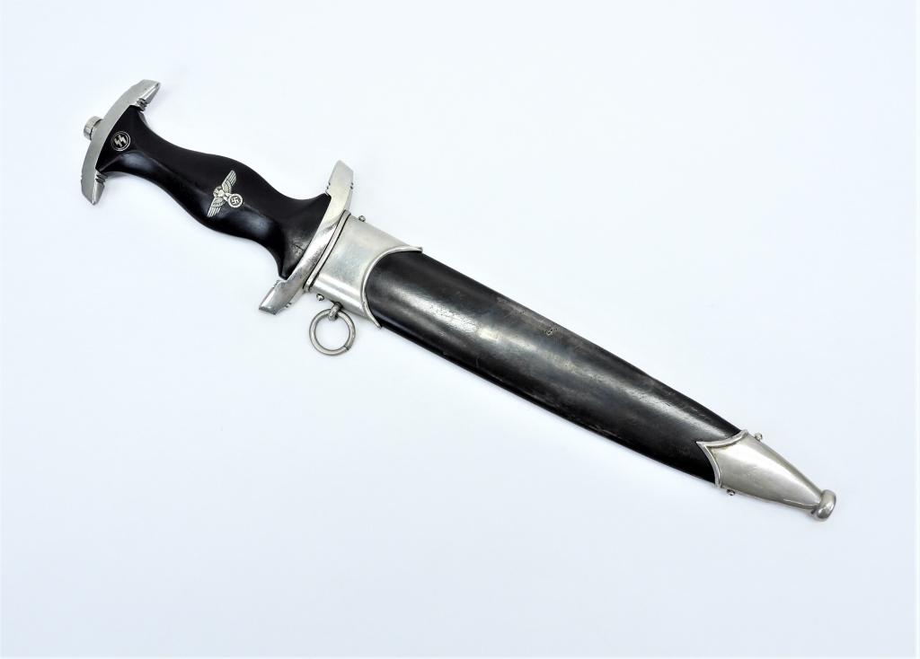 WWII German SS Dagger and Sheath: Germany,C. Nickel finished hilt, black wooden grip with eagle, swastika, and SS runes, blade etched "Meine Ehre heisst Treue", marked on the opposite side of the blade "E.P. & S./SOLINGEN", and a blac