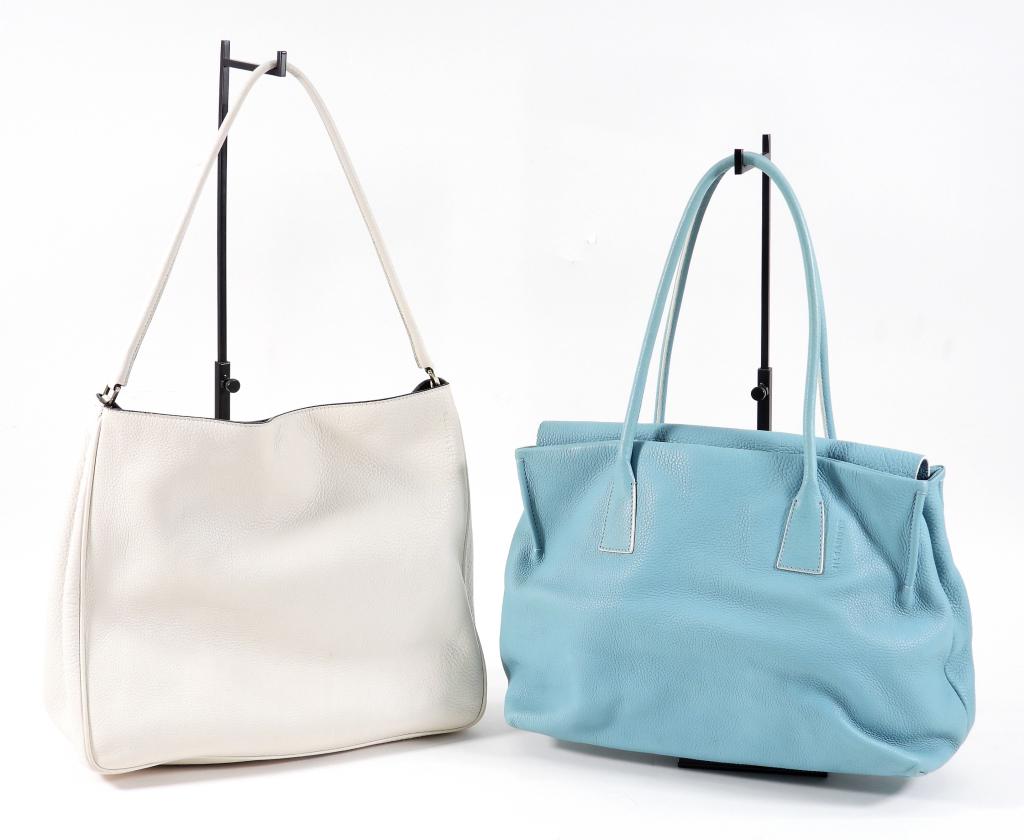 2PC Jil Sander Blue & White Leather Bags: Includes a double handled white leather bag with magnetic closure and silver metal hardware, and a double handled light blue leather bag with magnetic closure and silver metal hardware. Guaranteed aut