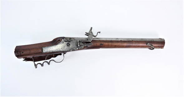 Diminutive German Wheelock Sporting Carbine: Germany C. mid 17th century .65 caliber rifled bore, walnut stock with raised cheek piece on the left side of the butt, a patch box on the right side of the butt, and two carved lines near the barrel