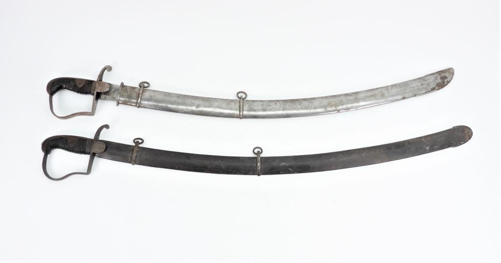 Two German Cavalry Sabers: A saber with "GL" engraved on the langet, wooden grip, and a steel scabbard; and a saber with some grip damage, and a steel scabbard.