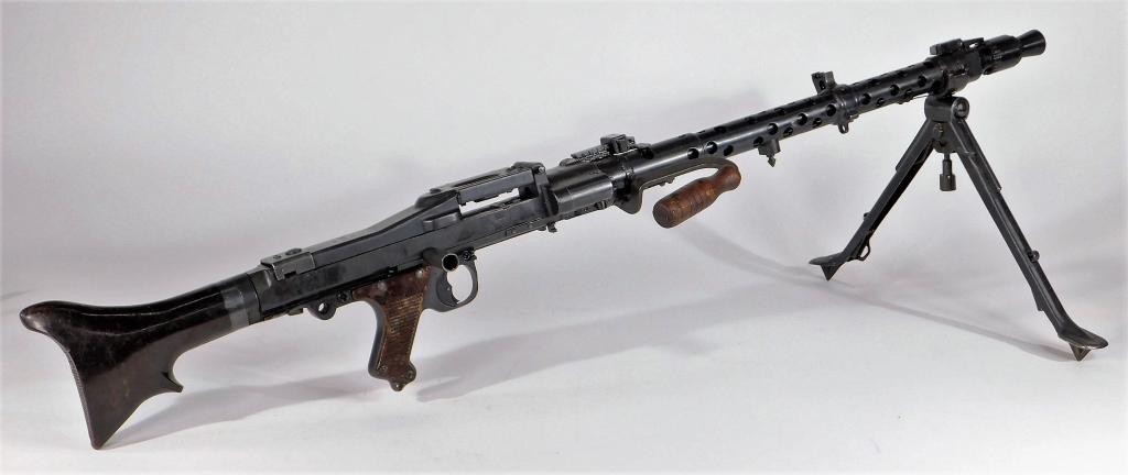 WWII German Inert MG-34 Machine Gun: Germany With a solid inert receiver, blued finish, marked on the top of the receiver "dtb/42/2376/k," with Bakelite grips and butt, carry handle, and a bipod.