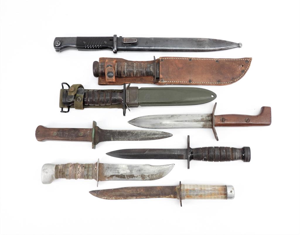 Eight Edged Weapons: An M4 bayonet and scabbard marked "CAMILLUS"; an M4 bayonet with no scabbard marked "IMPERIAL"; four theater-made fighting knives; a German K98k bayonet and scabbard with matching scabbard; and a U.S.