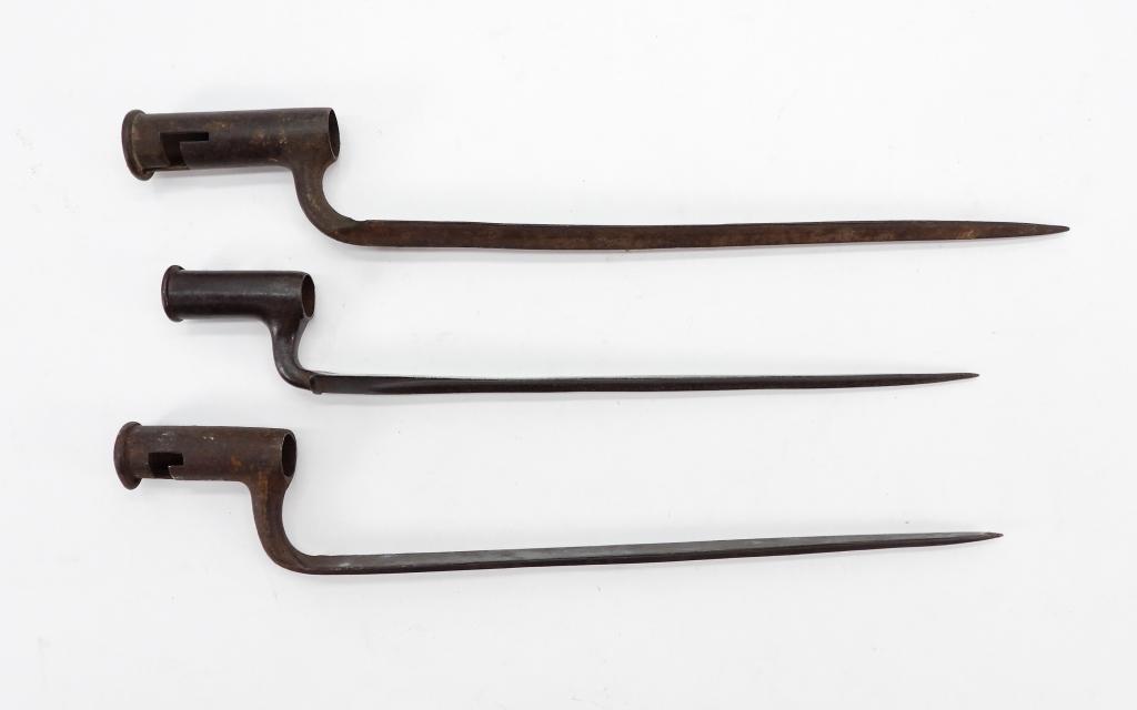 Three American-made Socket Bayonets: C. mid to late 18th century A fusil bayonet with an unmarked blade lg. 15 5/8"; a bayonet with an unmarked blade, a ring on the base of the socket, made for a top lug gun lg. 16 3/4"; and a bayonet wi