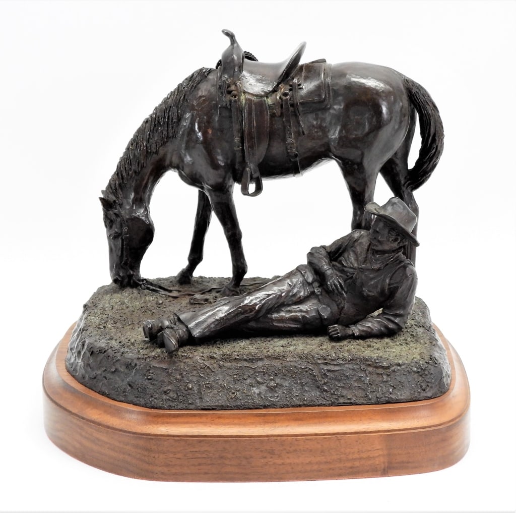 Carl Pugliese "Noonin" Sculpture: Sculpture depicting a cowboy sitting on the ground with his horse grazing behind him, marked on the back of the base "NOONIN/C 1981 CARL PUGLIESE/5/35". BronzeOverall ht. 11".Overall lg. 12 3/8"Signed