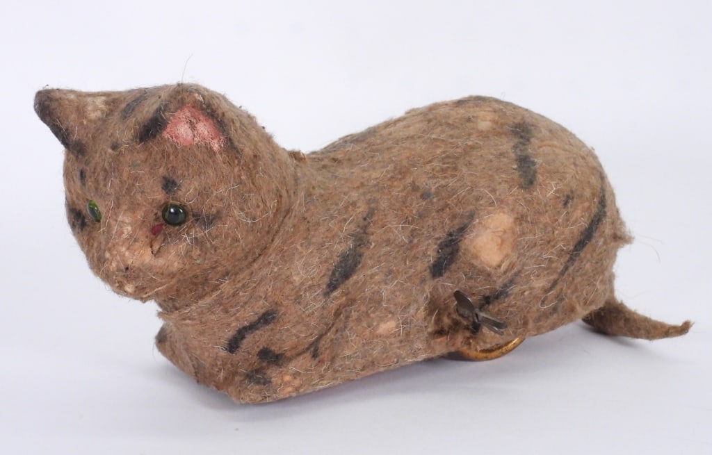Early German Clockwork Composition Cat Toy: Germany,Early 20th Century Early most likely German clockwork composition cat toy, mohair fur with painted stripping and glass eyes, when wound tail moves as cat roles forward, wear with scattered los