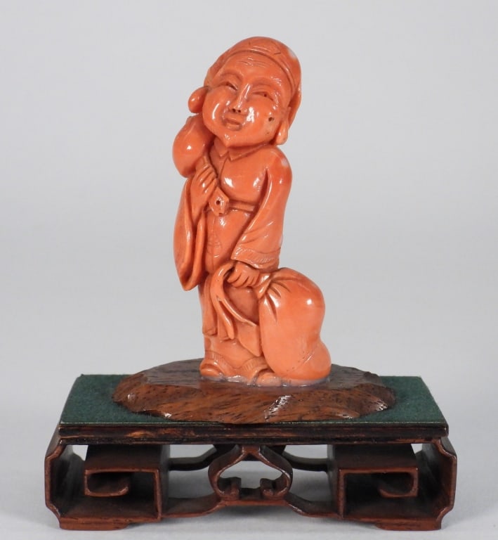Chinese Carved Coral Budai Figure: China,Late 19th- Early 20th Century Carved coral depiction of Budai holding a large bag at his feet while smiling. Coral Unmarked From the collection of an East Providence, Rhode Island estate. Approx