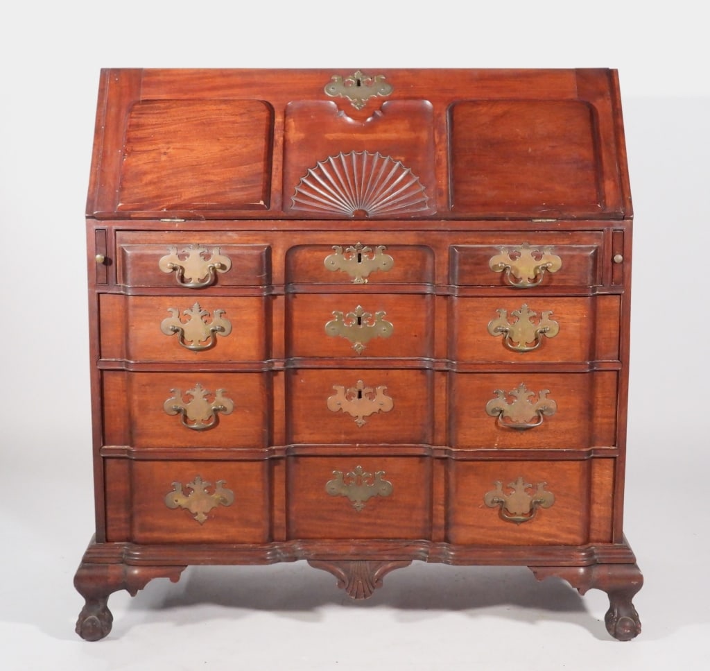 C.1900 Bench Made Mahogany Slant Front Desk: United States,C. 1900 The case is dovetailed constructed with shell carved slant front, revealing several fitted drawers and compartments, and large writing surface, with four block front graduated dr