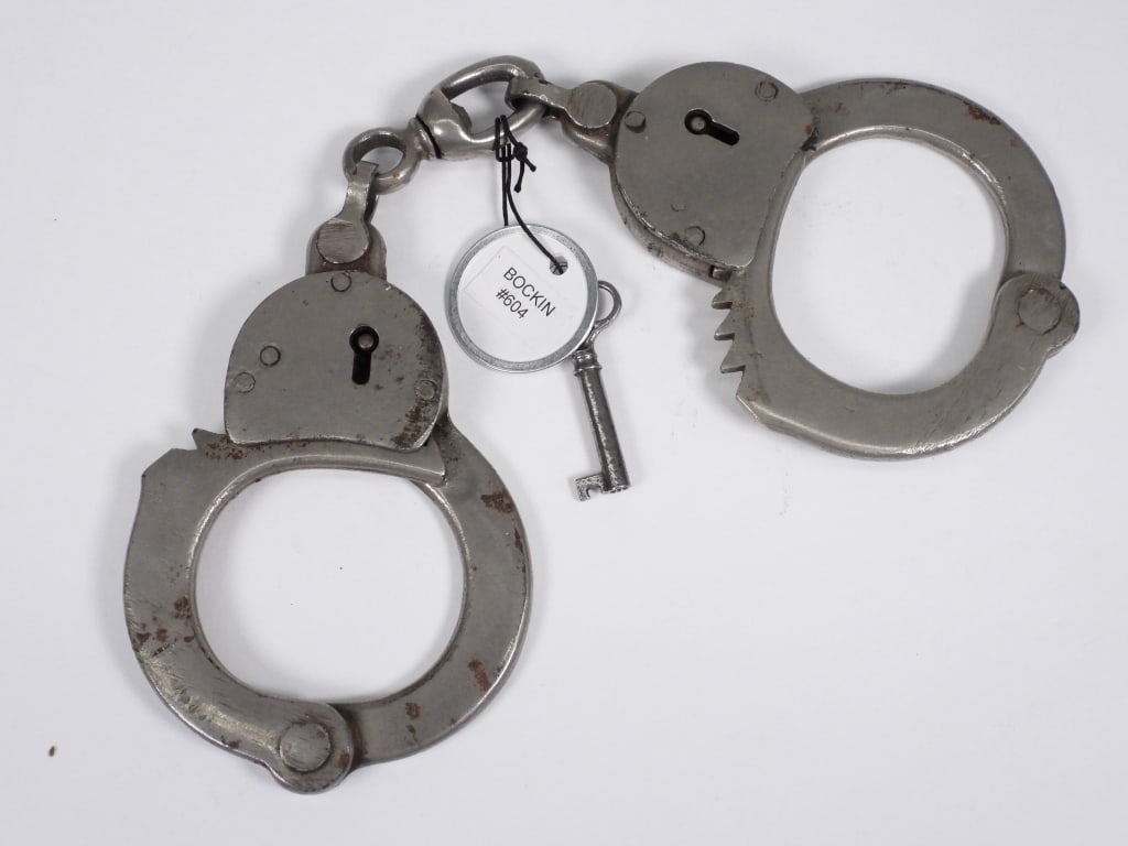 Bockin Steel Handcuffs: United States,20th Century Bockin steel swivel link handcuffs with original key. Illustrated on page 110, American Police Equipment, A Guide to Early Restraints, Clubs & Lanterns, by Matthew G. Forte.