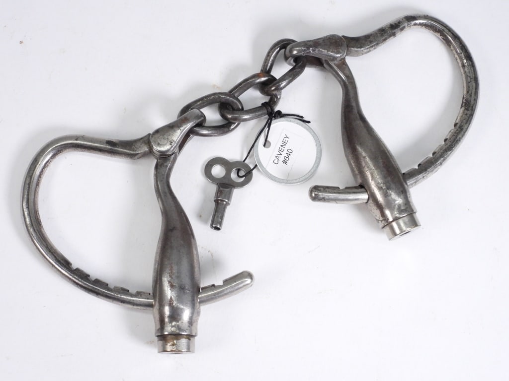 Caveney Invention Police Handcuffs: United States,20th century Caveney Invention steel handcuffs with 3 twisted links, original key. Illustrated on page 104, American Police Equipment, A Guide to Early Restraints, Clubs & Lanterns, by M
