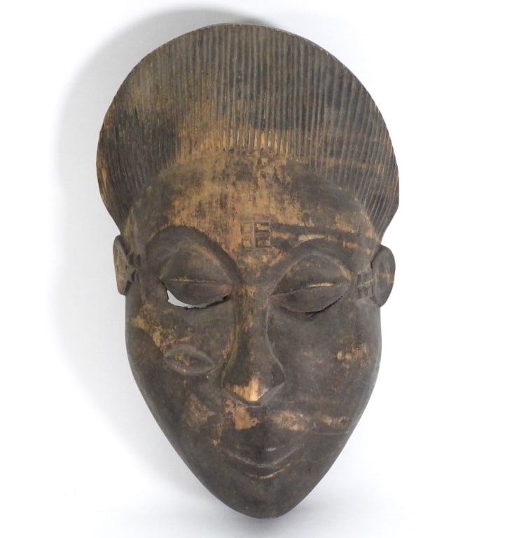 African Carved Wood Mask: Africa 20th Century Carved wood mask of a face depicting upturned lips, hooded eyes, and hooked nose. Wood,Approx. 14 1/2" t x 8 1/2" w x 5" d. From the collection of a Fort Pierce, Florida estate. Th