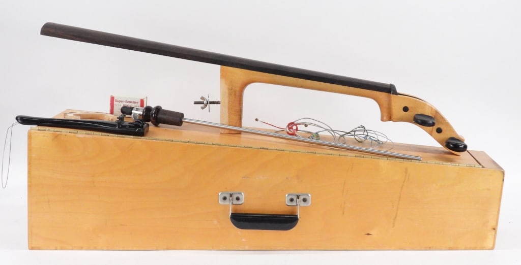 Custom Made Collapsible Practice Cello: United States 20th Century Compact hinged back cello opening to a storage compartment housing the neck, bow, end pin, tail piece, and bridge. Wood, metal,Body 30" t x 8 1/2" w x 8" d.Neck w/ fingerboa