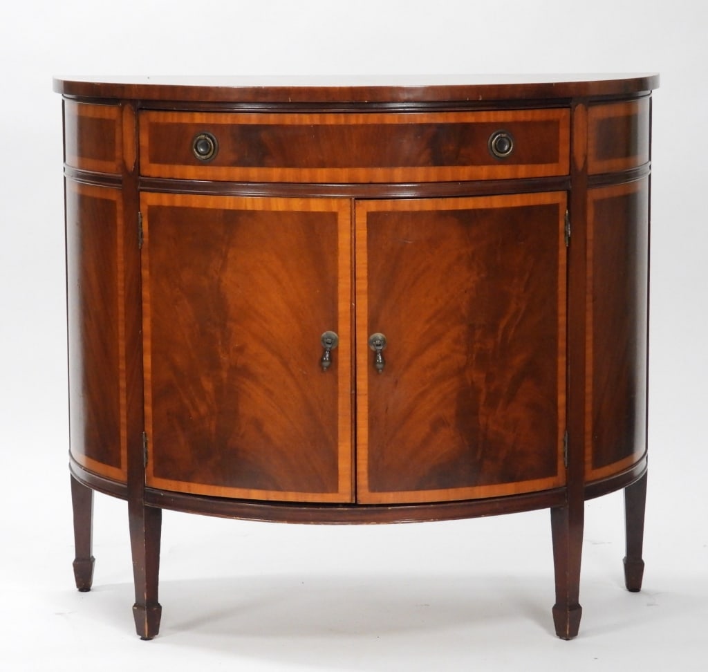 Flame Mahogany Banded Inlay Demilune Console: United States Early 20th Century Half moon top over single drawer over two doors opening to two shelves supported by spade feet. Mahogany,33" t x 38" w x 19" d. From the collection of a Cranston, Rhod