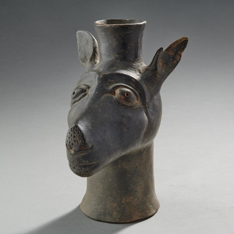 Pre-Columbian Pottery Vessel: Peru,Ca. 14th century A blackware Chimu culture kero in the form of a llama head, on high flaring hollow base. H. 8.75".H. 22 cm Old Rhode Island Collection, formed 1960's-80's.