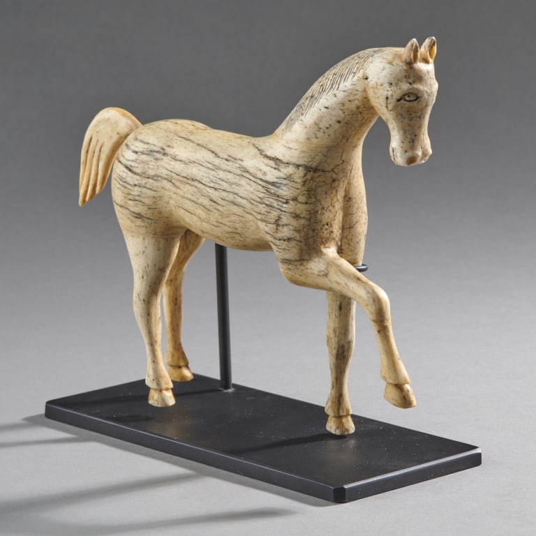 Fine And Early Whale Bone Carving Of A Horse: Continental?,Ca.18th century Possibly of continental origin. The figure with separately carved head, legs and tail, showing great age. Custom stand. L. 7.75" H. with stand: 6 5/8".L. 19.69 cm H. with 