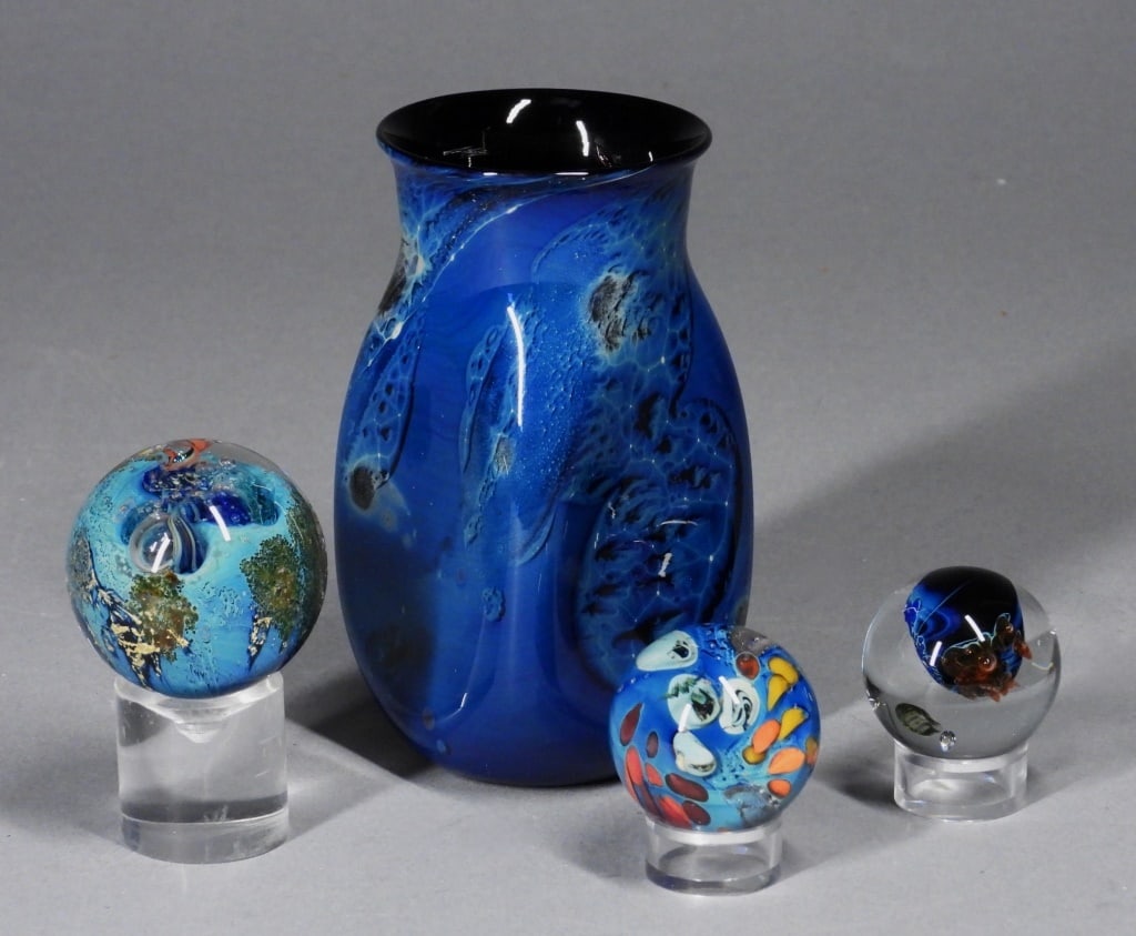 4PC Josh Simpson Art Glass Paperweights & Vase: New York, Massachusetts,b.1949 Includes a mottled blue vase, and three marbles of varying size with encapsulated interiors appearing aquatic in nature. Glass,Smallest 1 1/2" dia..Largest 5" t x 2 1/2"