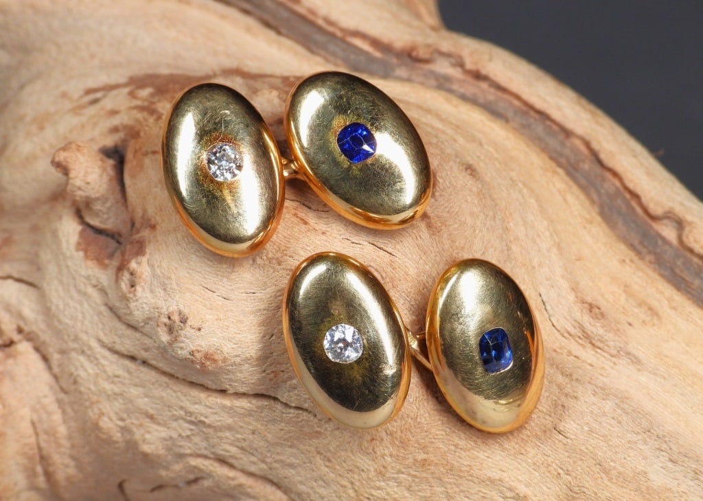 Tiffany & Co Edwardian Diamond Sapphire Cufflinks: United States,First quarter 20th century Pair of Edwardian period 18K yellow gold cuff links each set with one 4mm x 3mm sapphire and one 3.5mm mine cut diamond totaling approximately .34ctw. Weight a