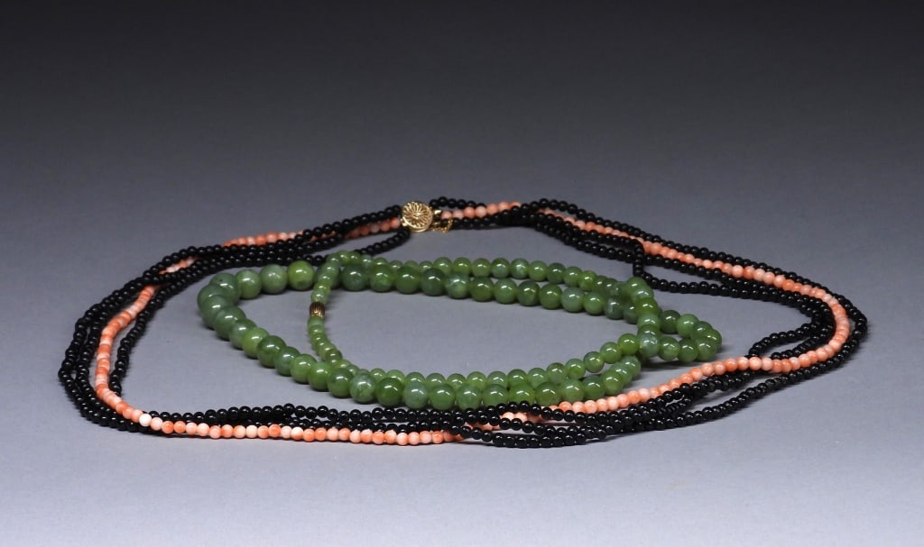 2PC Hardstone & Coral Beaded Necklaces: China,20th Century Includes a green hardstone beaded necklace with 14K yellow gold clasp, and a four strand coral and obsidian beaded necklace with 14K yellow gold clasp. Hardstone carving in China ca