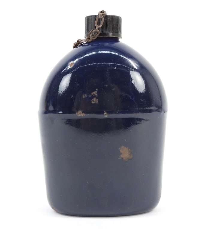 WWII Blue Porcelain Canteen: United States C. 1942 Unmarked blue porcelain canteen with a black Bakelite cap. Overall ht. 7 1/4".Overall wd. 5"