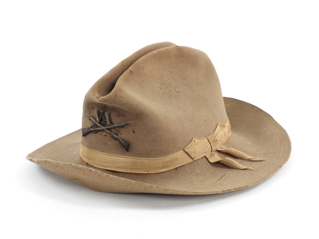 Virginia Spanish-American War Campaign Hat: United States C. 1890s Light brown felt campaign hat with star pattern vents on the sides, a brass pin on the front with crossed rifles and "VA", silk grosgrain ribbon around the crown, three rows of
