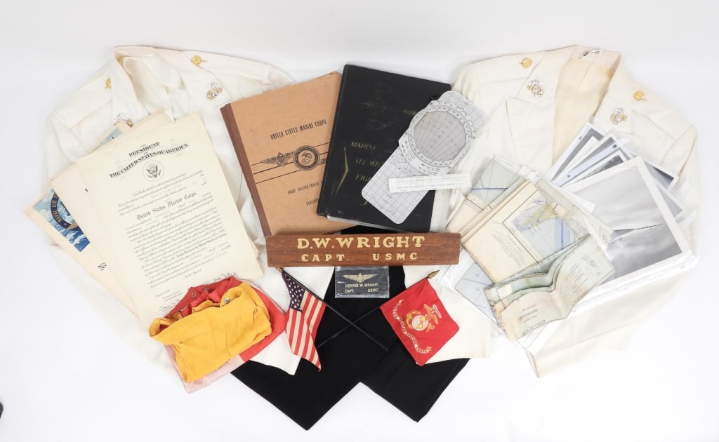 USMC Uniforms & Ephemera of Lt. Col. Dennis Wright: United States C. 1950s-60s Two dress white USMC jackets with brass buttons, eagle, globe, and anchor insignia on the lapels, black dress trousers, desk nameplate, commissions, maps, flight logs, image