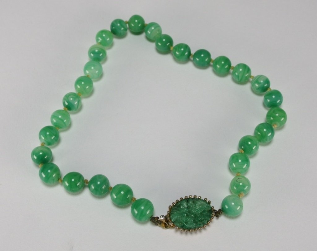 Chinese Peking Glass Bead Joseph Mazer Necklace: CHINA, early 20th C.A fine necklace with hand made Peking glass beads with variegated coloration of green and white. The clasp has a glass formation of flowers surrounded by a gold plated frame signed