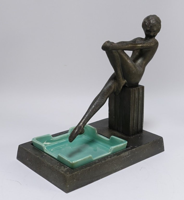 Frankart Patinated Metal & Porcelain Nude Ashtray: Frankart Patinated Metal & Porcelain Nude Ashtray"UNITED STATES, ART DECO A signed Frankart Inc. patinated metal and glazed porcelain figural nude ashtray. The ashtray depicts a stylized female form p