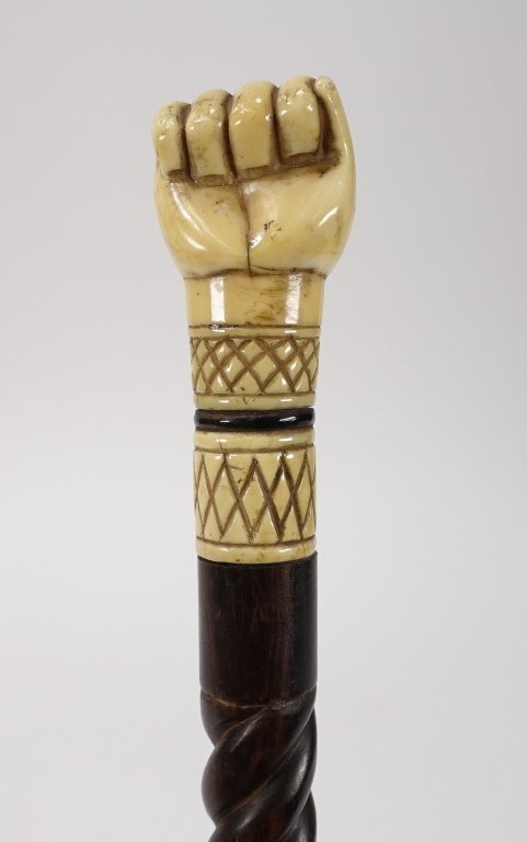 Sailor Made Rosewood Whale Tooth & Bone Cane: Sailor Made Rosewood Whale Tooth & Bone Cane"UNITED STATES, 19TH CENTURY A 19th century sailor made clenched fist cane. Pommel carved whale tooth with spiral turned rosewood shaft and whale bone ferru