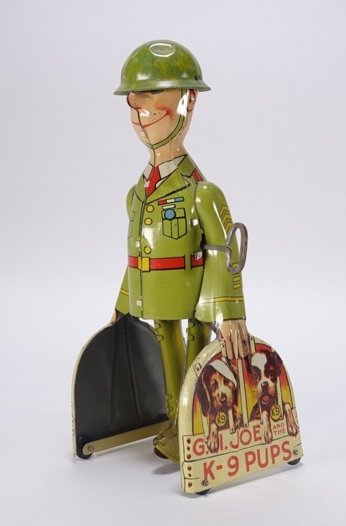 1940's Unique Art Tin Lithograph G.I Joe Windup: A great example of a 1940's Unique Art tin lithograph G.I Joe and the K-9 Pups windup walker. The toy is in working order with minimal wear. Minor dents to soldiers helmet. G.I Joe measures 9" tall