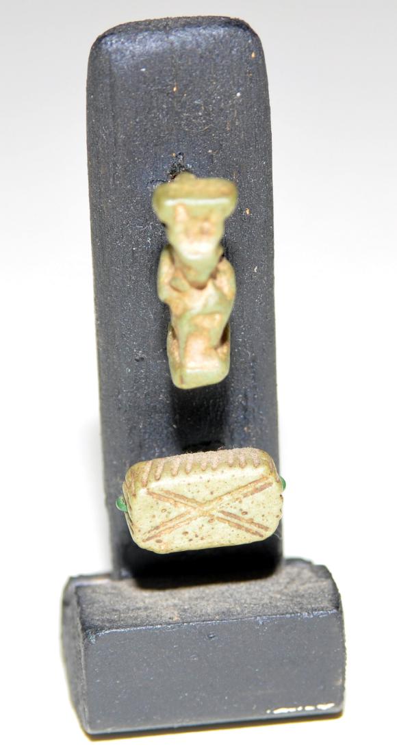 Egyptian beads deity ancient: Egyptian beads ancient - 2 beads on stand inc. seated deity - x design on small drilled bead - we believe that these are ancient material- however we are not experts so you are the expert. -about 2 1/