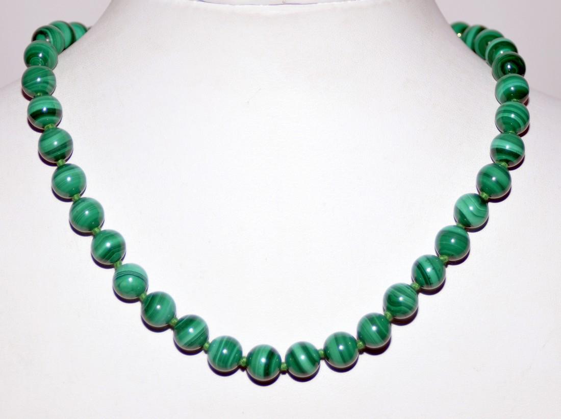 Malachite beads knotted necklace: Malachite beads approx. 10 mm size knotted on green silk and about 18 inches long.