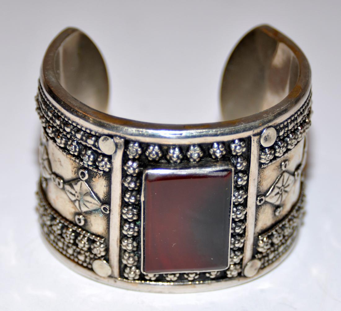 Bracelet cuff carnelian tribal: Carnelian large cabochon bracelet - bezel set stone tribal design with 2 side stones(12 x 45 mm) - bracelet is about 2 inches wide with nice chasing and workmanship. Center stone about 24 x 32 mm.