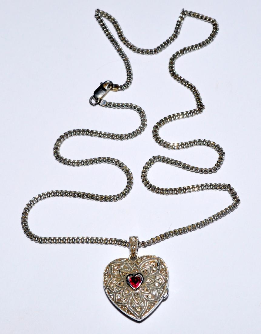 Locket sterling garnet heart on chain: Sterling locket with heart shaped garnet gemstone in center- on chain vintage hinge and latch work well on locket- heart is about 1 inch in diameter and chain is approx. 18-20 inches long . Nice condi