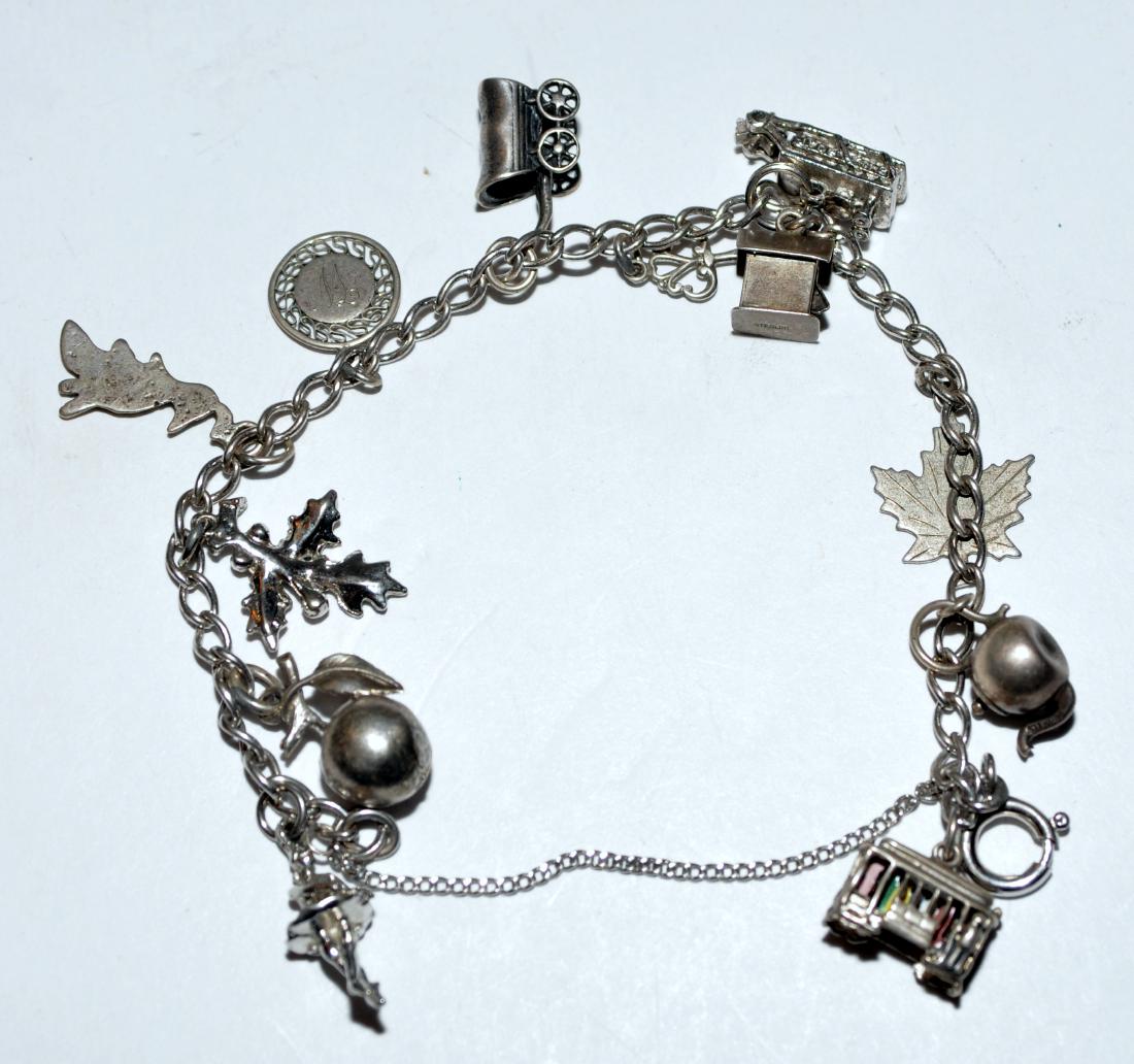 Sterling vintage charm bracelet: Vintage sterling charm bracelet with about 12 charms including early locomotive, bird house, Canadian maple leaf, stage coach, apple etc.-about 6 1/2 inches long