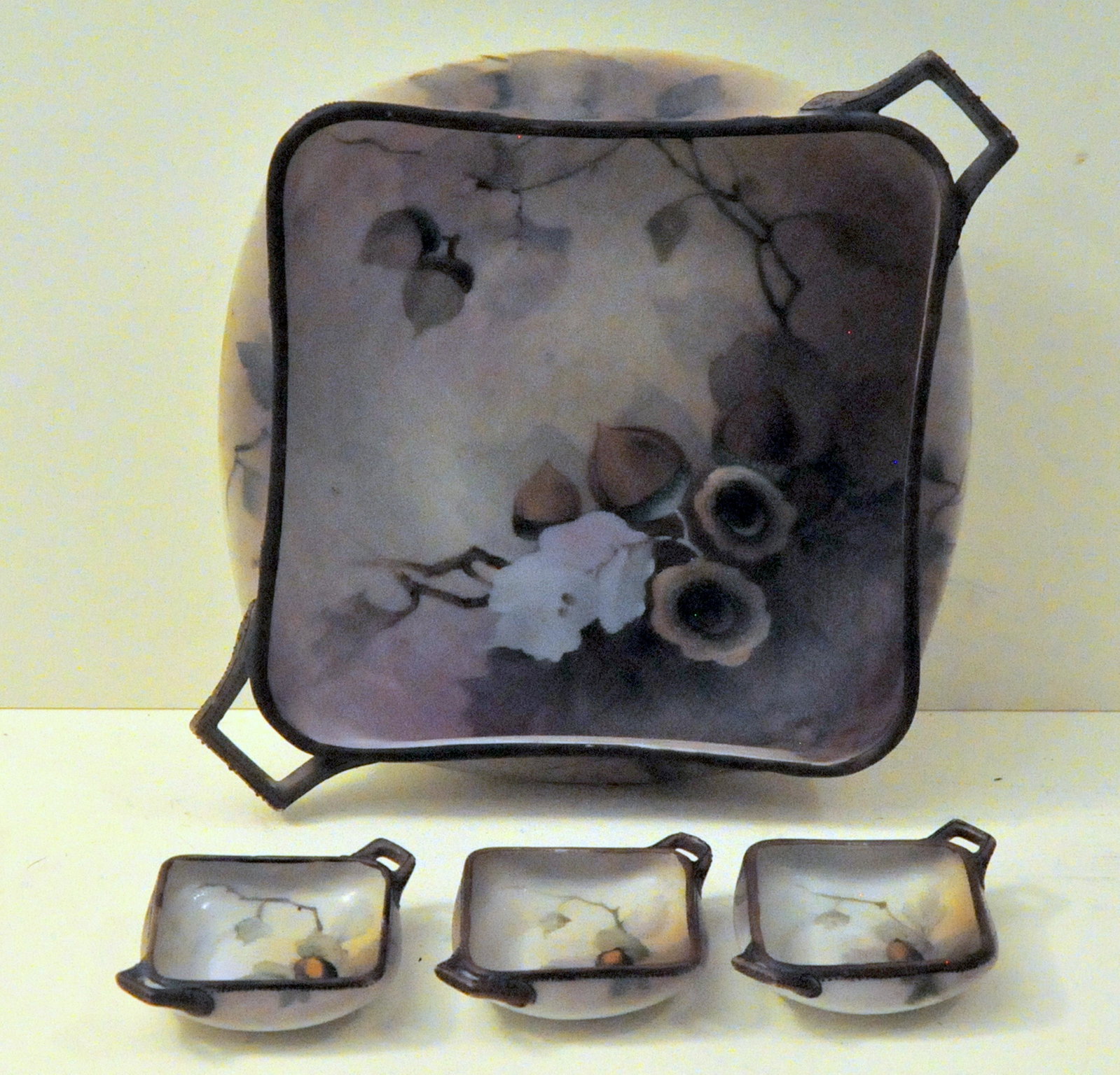 Nippon nut dish with 3 small matched miniatures: Marked Nippon handled hand painted master bowl with 3 small matched miniature dishes . Probably for nuts or fruit. Very nice condition and beautifully made.