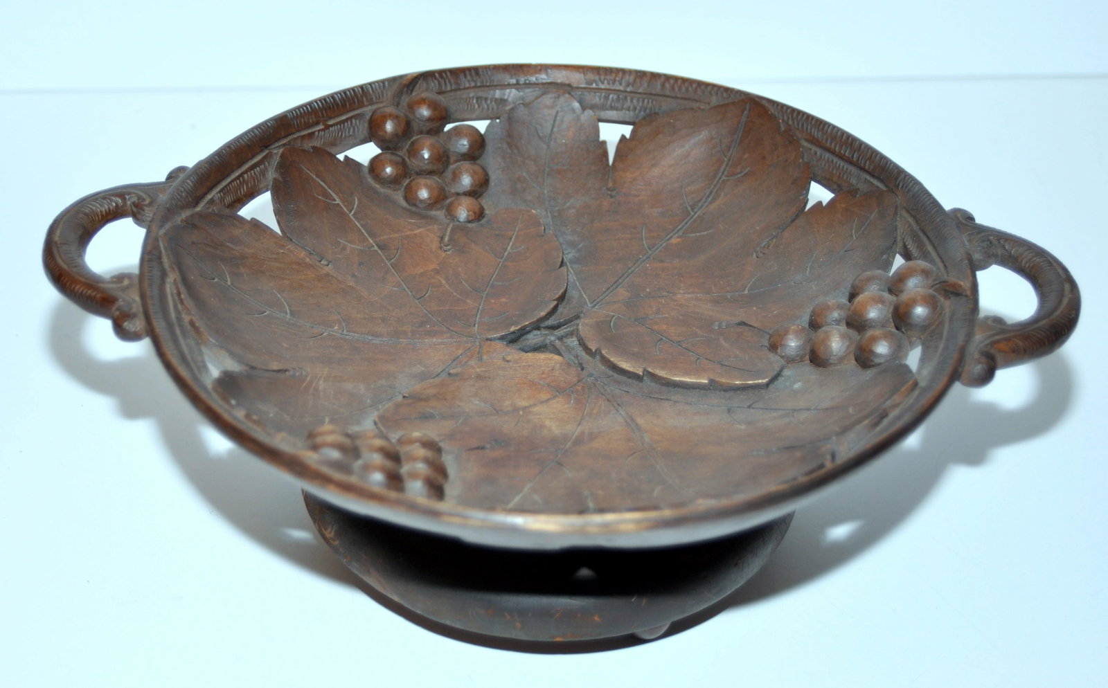 Carved wood Black Forest music box bowl: Carved wooden bowl music box vintage Swiss -old hand carved wooden bowl with grapes and grape leaves. Handles on either side -piercework design and marked on base Made in Switzerland. About 11 1/2 inc
