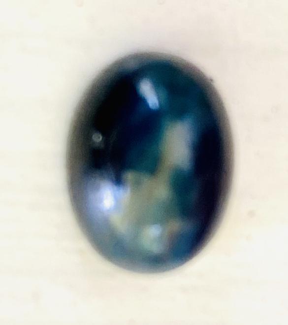 Rare apatite cats eye cabochon: RARE oval apatite cats eye cabochon in dark blue color . This rare gemstone . This stone exhibits a rare optical trait known as chatoyancy. It is best viewed under direct light.