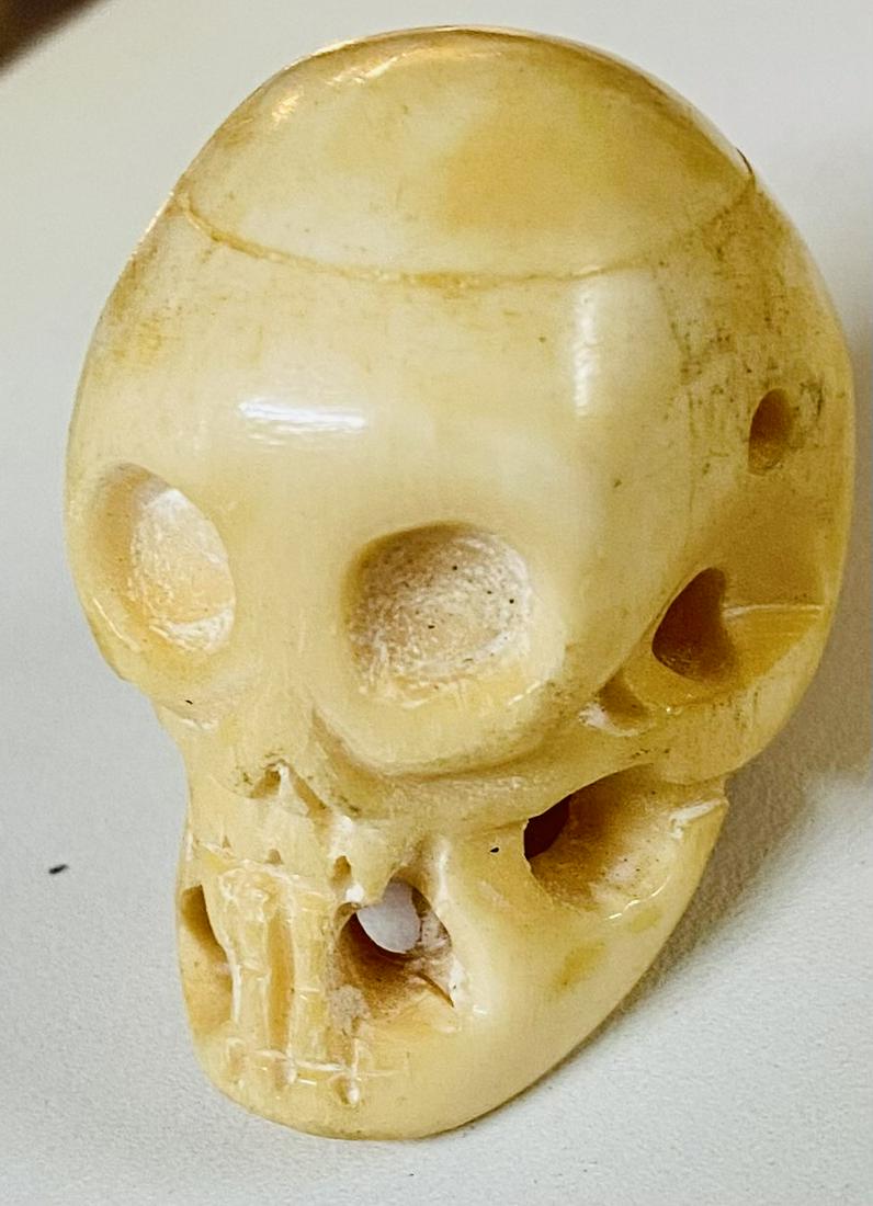 Bone carved skull drilled: Cow bone skull carved one of a kind with drilled holes for putting on chain or rope. About 1 1/2 inches across and good condition.