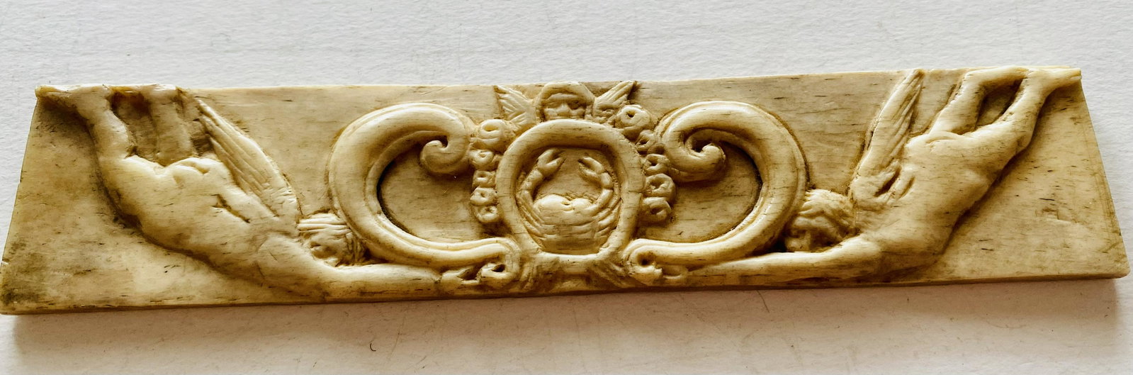 Carved antique bone cherubs: Hand carved angel cherub design with crab in center rectangular bone - probably cow- deep carving about 5-6 inches long and in nice condition