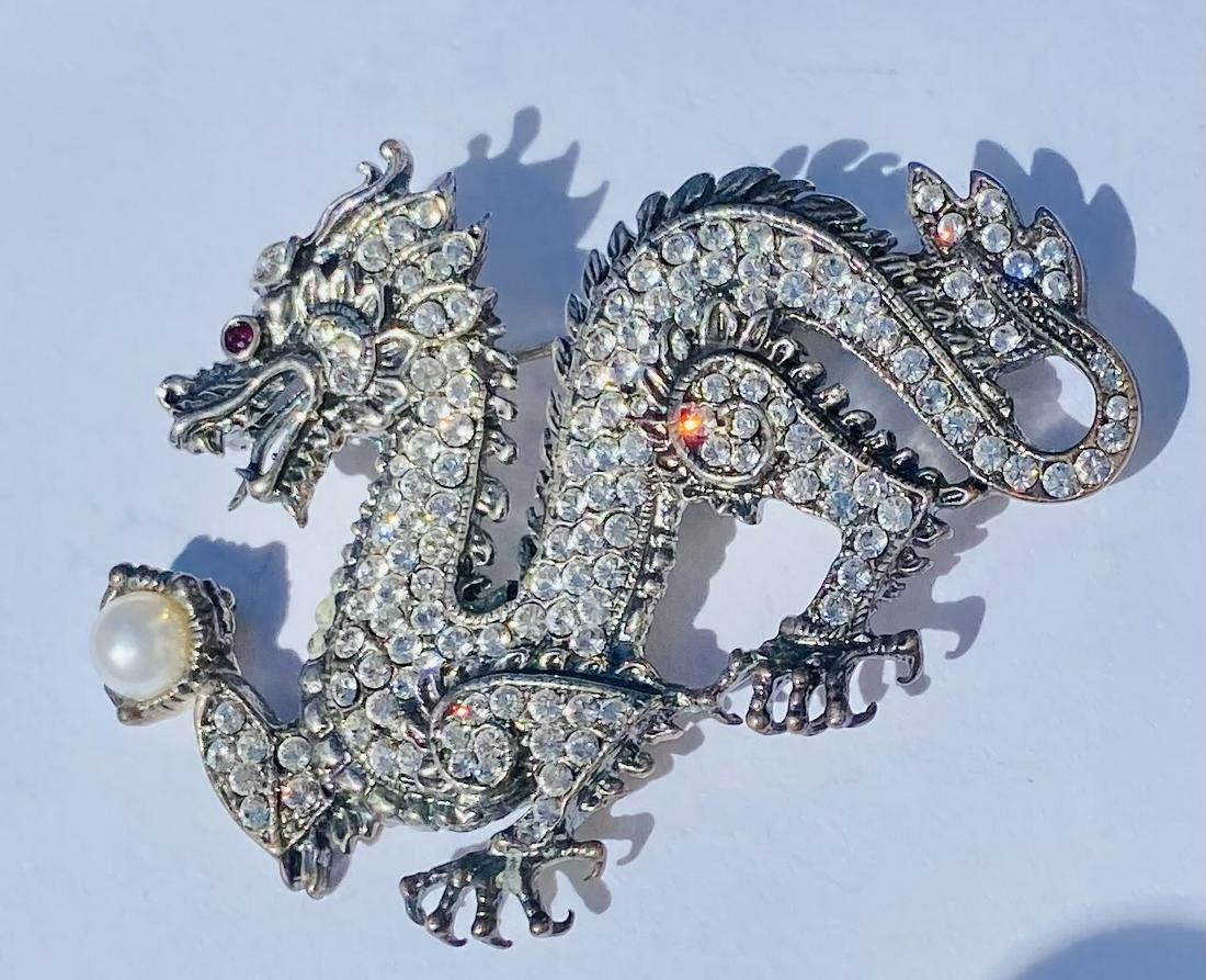 Sterling dragon pin Franklin Mint: Dragon pearl sterling pin with many clear stones set into body of this exotic dragon marked Franklin Mint on reverse and sterling as well - good condition and a wonderful design. About 2 3/4 inches x
