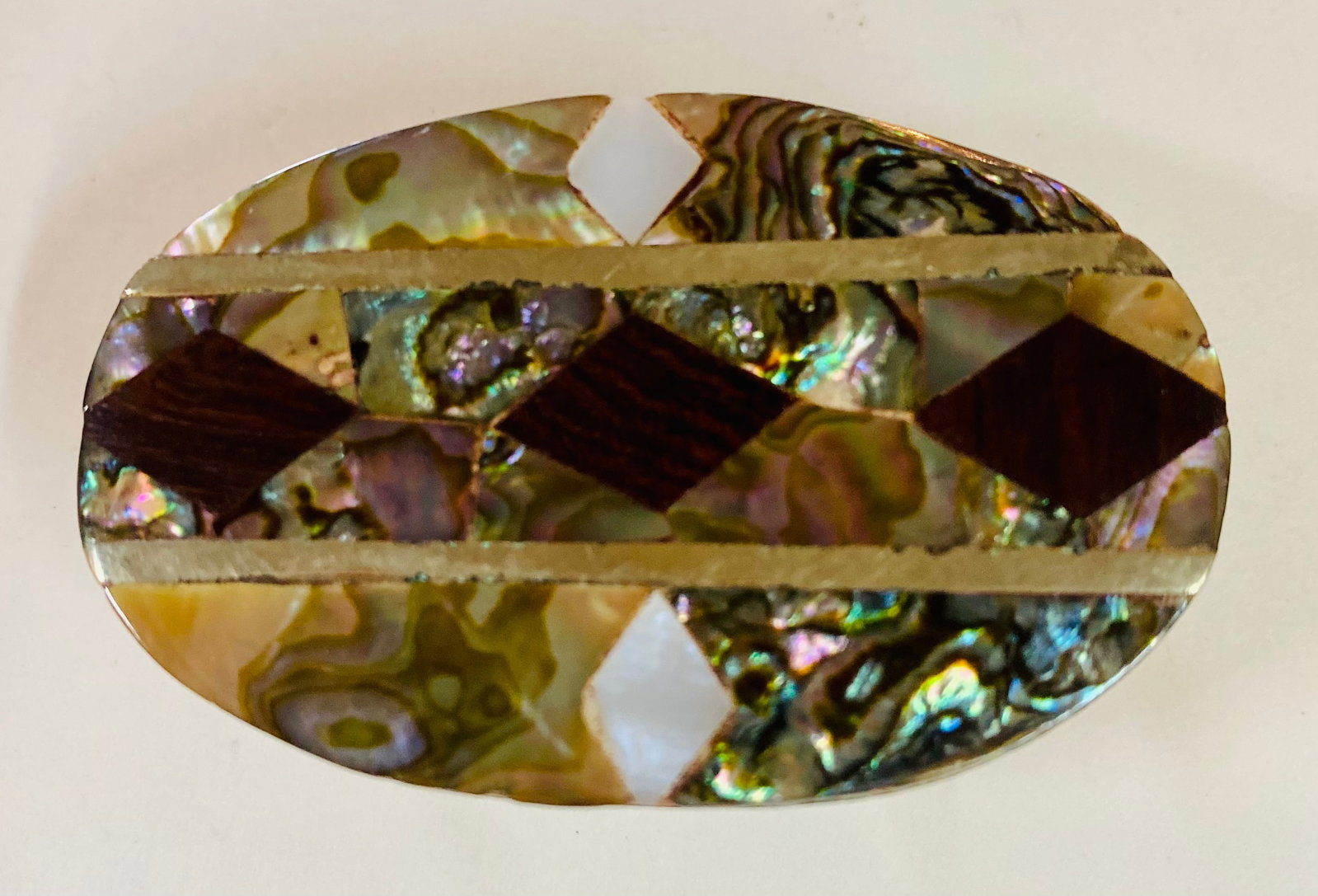 Oval inlaid abalone onyx belt buckle: Marked Mexico on back - oval belt buckle as shown with nice inlay of abalone , mother of pearl and possibly onyx as well- about 2 - 3 inches long and condition is good.