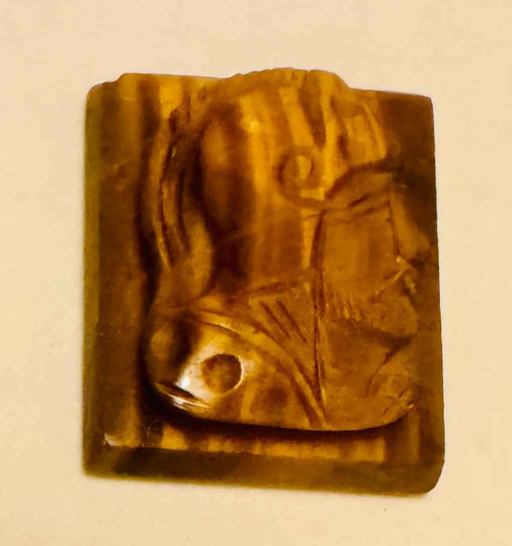 Tiger eye carved knight head: Knight with helmet carved in tiger eye rectangle -- about 3/4 inches across and condition is very nice. Color is great too.