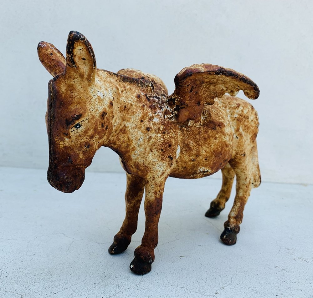 Antique Cast Iron Flying Donkey-Piggy Bank: Antique Cast Iron Metal Flying Donkey Wings Coin Bank.The piece has an enamel finish, it has a rusted patina, still shows well. Measurements: 8 inches deep x 4 inches deep x 5.25 inches high All items